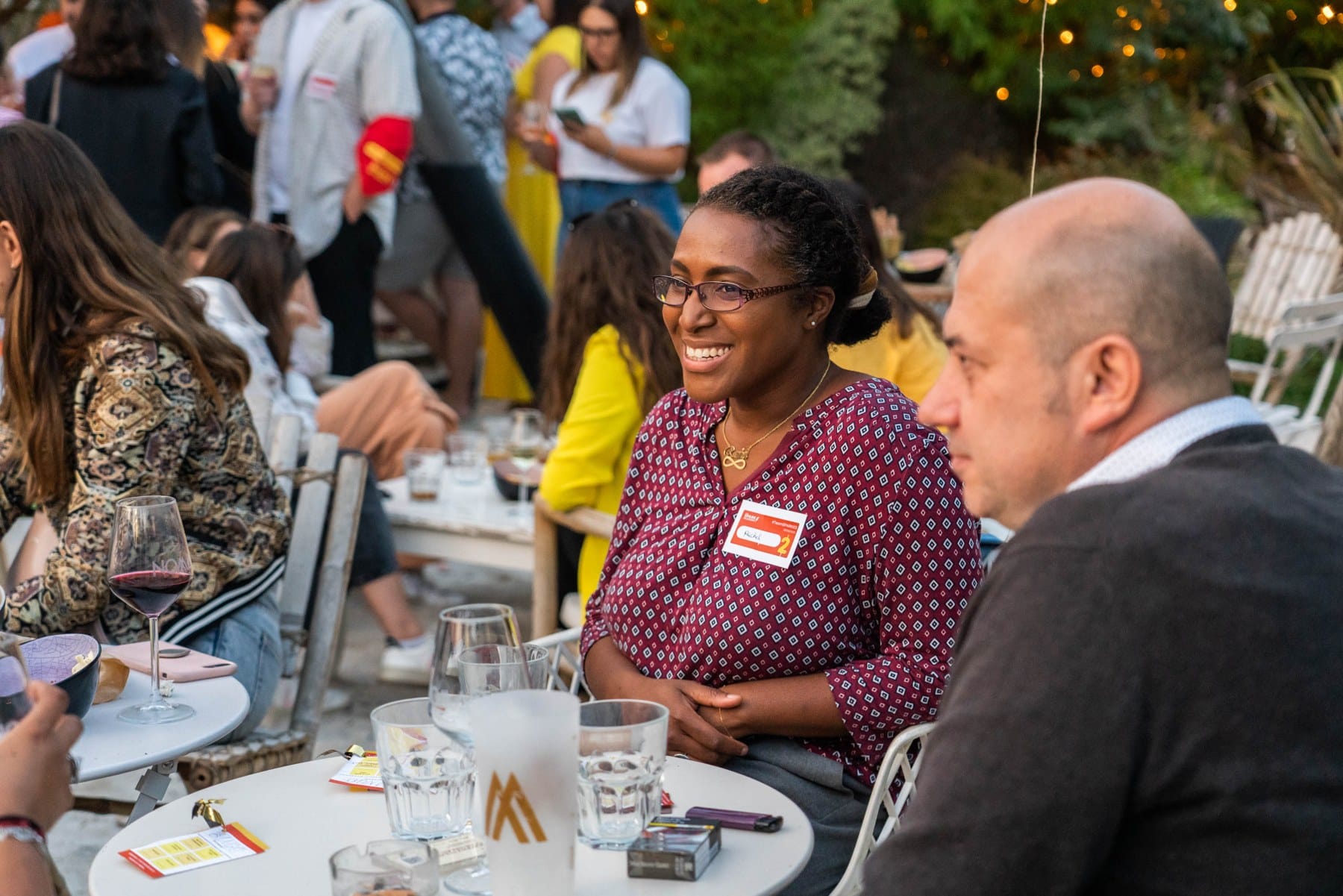 Des sourires et une conversation autour d'une table dans le jardin, à la SPARTY 2023.